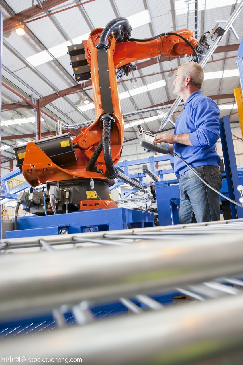 工人在制造工厂的生产线上控制机械吊装